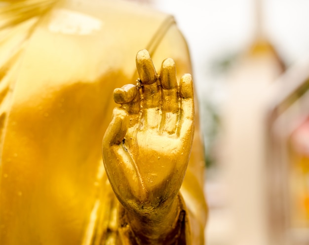 Estátua de buda de ouro de mão no templo tailandês