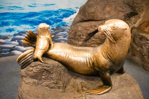 Estátua de foca com filhote em pedra contra o pano de fundo da paisagem marinha no Oceanário