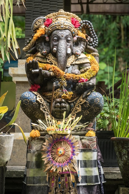 Estátua de ganesh decorada com flores em um templo em ubud bali indonésia