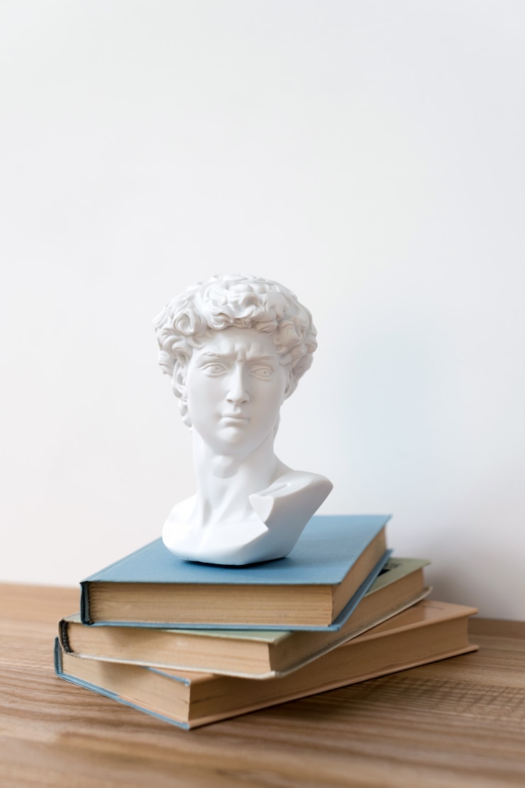 Foto estátua de gesso da cabeça de david em uma estante de livros