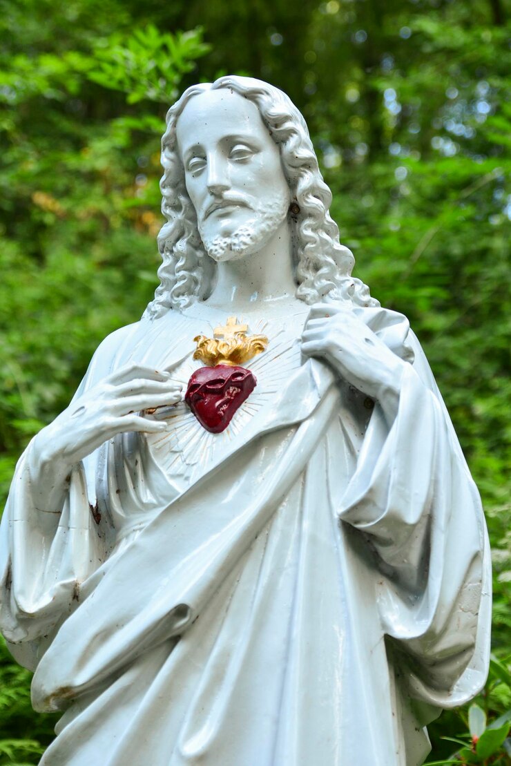 Foto estátua de jesus com um coração vermelho