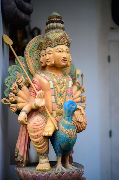 Estátua de madeira do deus hindu Murugan montando um pavão