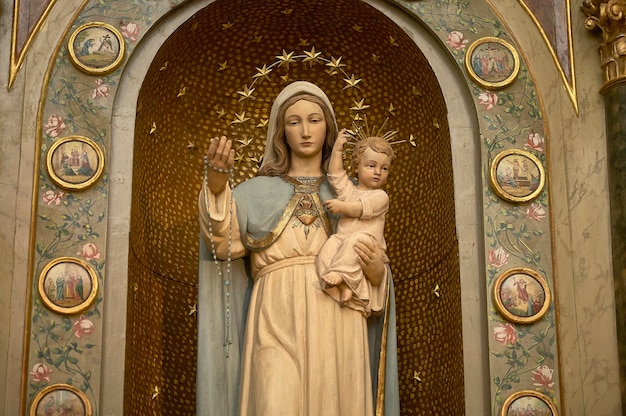 Estátua de Maria segurando um menino Jesus, símbolo da religião católica e cristã.