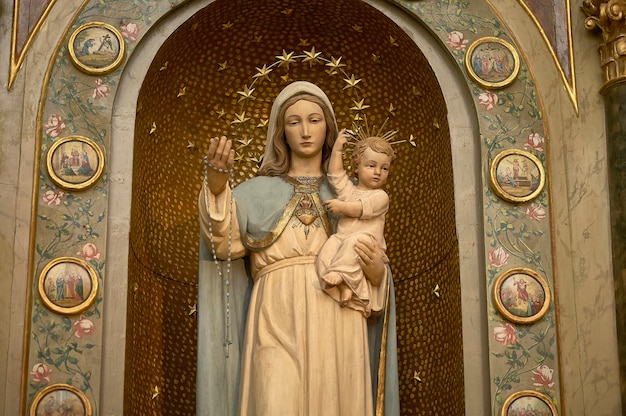 Estátua de maria segurando um menino jesus, símbolo da religião católica e cristã.