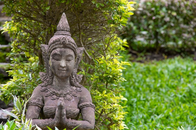 Estátua de pedra velha de uma mulher para a decoração do jardim.