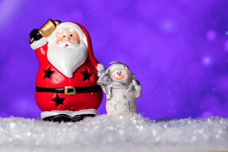 Foto estátua de santa claus de cerâmica e figura de boneco de neve de pé na neve