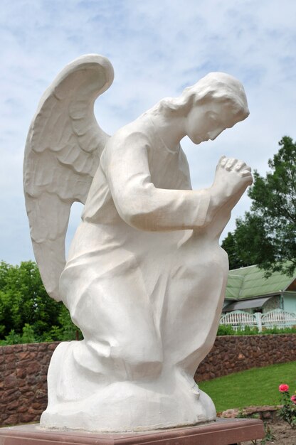 Estátua de um anjo em oração no jardim.