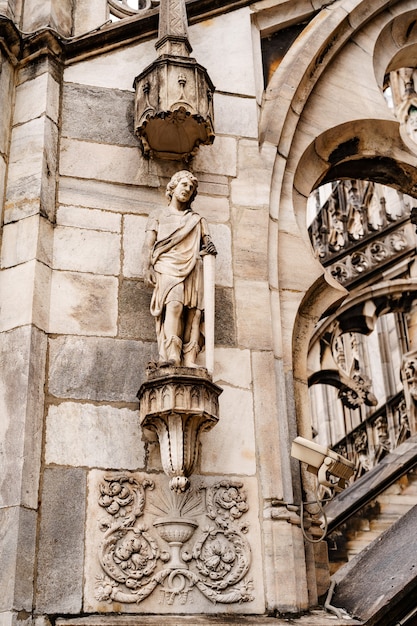 Estátua de um homem com uma espada em um pedestal na fachada do duomo de Milão itália