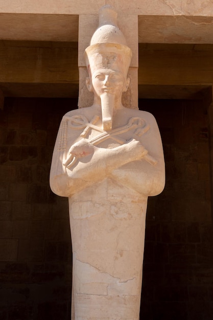 Foto una estatua de un dios egipcio frente a un templo