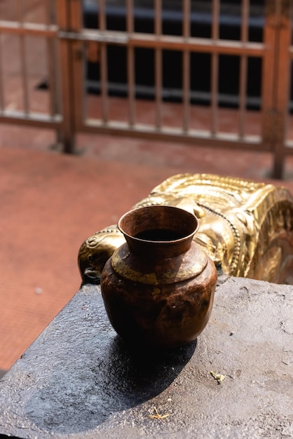 Una estatua dorada de un león está detrás de un jarrón.