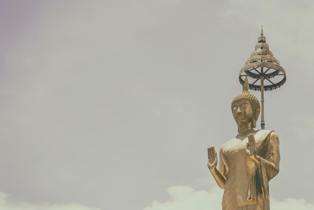 Estátua dourada de Buda de pé no sol copia templo de viagens espaciais