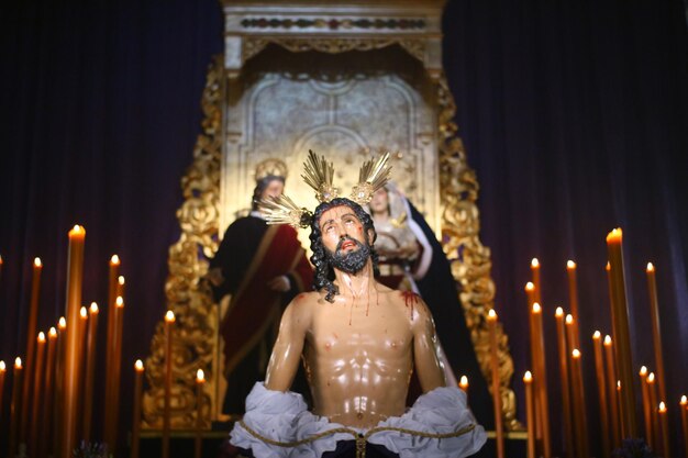 Foto estátua em meio a velas iluminadas na igreja