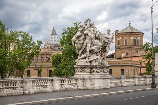 Foto estatua famosa del ponte vittorio emanuele ii y la cúpula de la basílica de san pedro roma italia