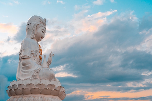 Estatua de guan yin con fondo natural cielo.