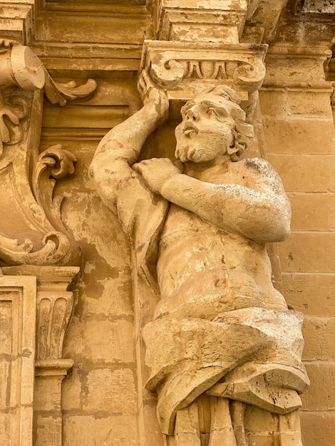 Foto una estatua de un hombre sosteniendo un cuerno y un letrero que dice gour