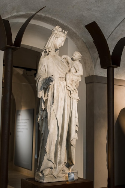 Estatua de la iglesia con un niño en el museo católico en italia