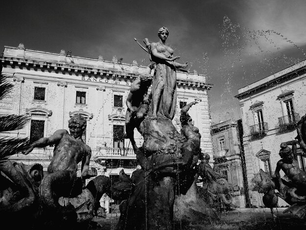 Estatua junto a un edificio histórico contra el cielo