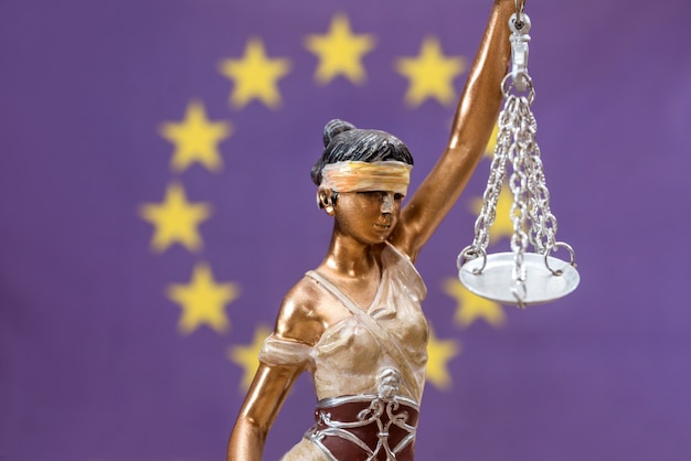 Estatua de la justicia contra la bandera de Europa