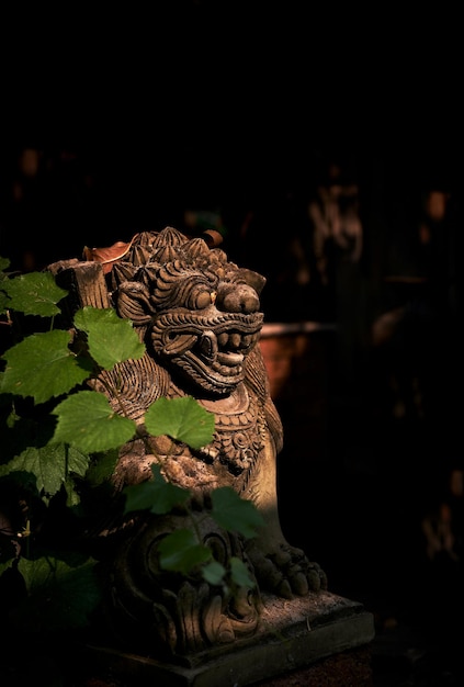 Foto una estatua de un león con una hoja verde cubriéndolo.