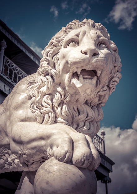 Estatua de un león que pone una pata en una pelota