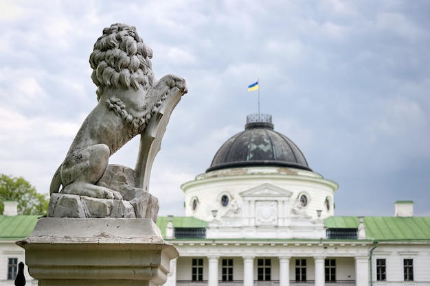 Estatua de león sosteniendo un escudo en sus patas. Regal león apoyándose en el escudo heráldico vacío cerca de la entrada del castillo