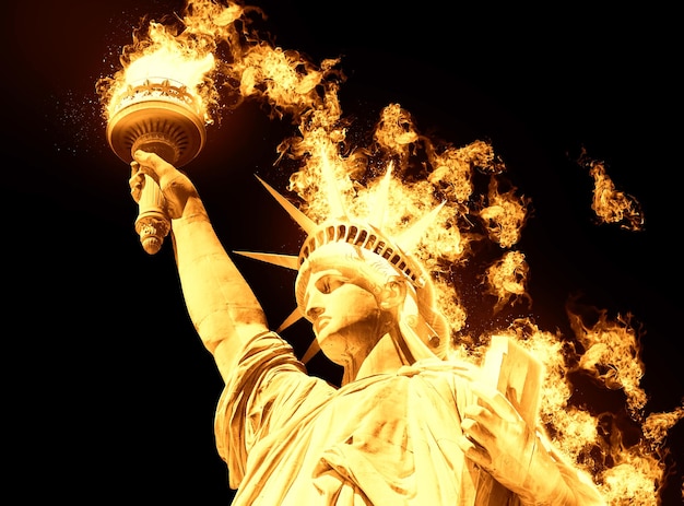 Estatua de la libertad con fuego ardiente aislado sobre fondo negro