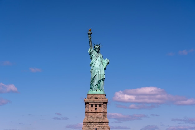 La estatua de la libertad bajo la pared del cielo azul, la ciudad de Nueva York