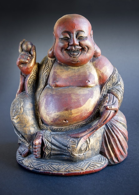 Estatua de madera tradicional de Buda chino aislado sobre fondo oscuro