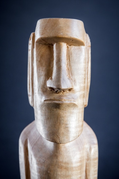 Estatua de madera tradicional de un moai de Isla de Pascua. Fondo oscuro