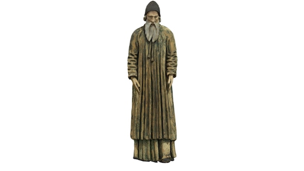Una estatua de un monje con barba larga y sombrero.
