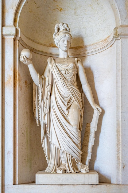 una estatua de una mujer con una corona y una cruz en ella