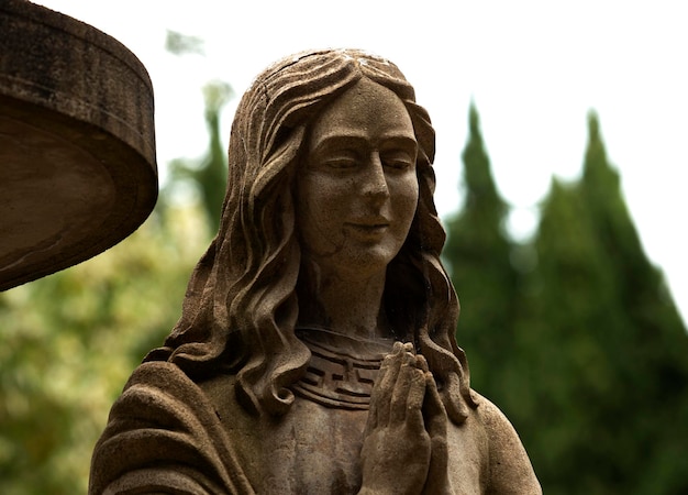 Foto una estatua de una mujer con las manos juntas y la palabra la palabra en el frente