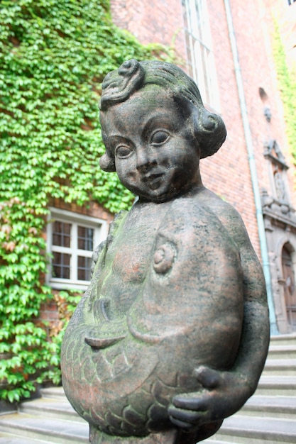 Estatua de niña y pez en un edificio antiguo en Estocolmo utilizado como ayuntamiento