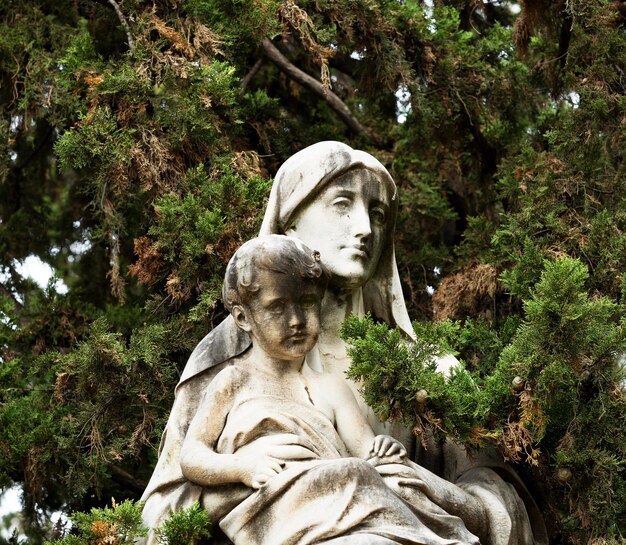 Una estatua de un niño y una mujer con una manta en la cabeza.