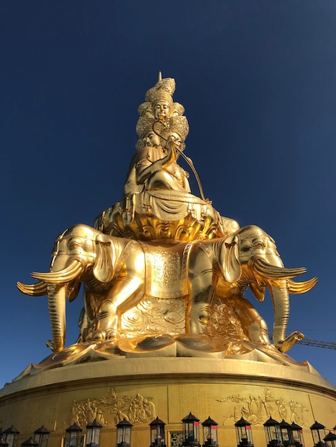 Foto una estatua de oro de un buda y un elefante