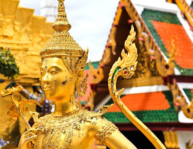 Estatua de oro del kinnara en el palacio magnífico Bangkok, Tailandia.