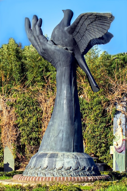 Una estatua de un pájaro con alas y un pájaro encima.