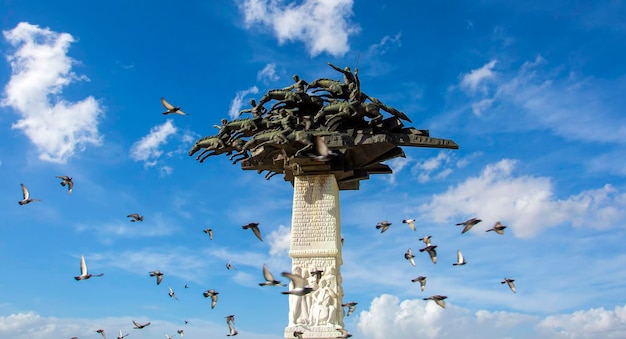 una estatua de un pájaro está rodeada de palomas