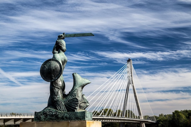 Estatua por el puente contra el cielo nublado