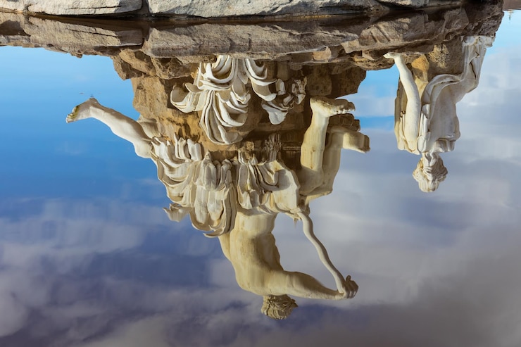 Foto estatua que se refleja en el agua