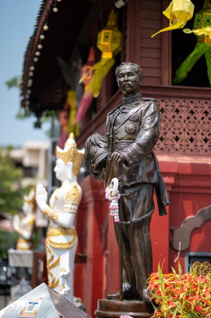 Una estatua del rey de tailandia se encuentra frente a un edificio.