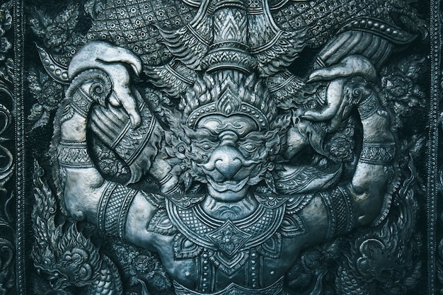 Estatua de talla de acero budista Garuda sobre fondo negro el templo de la puerta en Tailandia