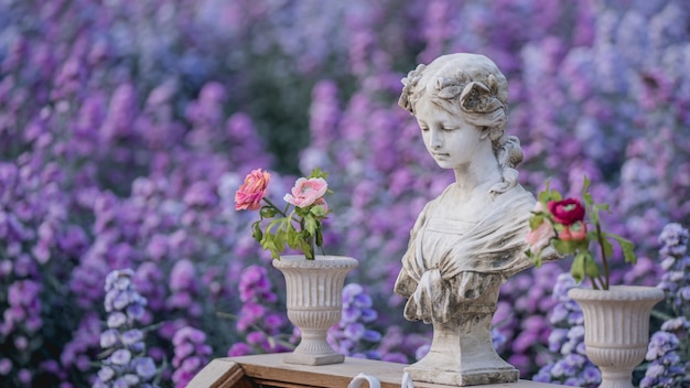 Estatua vintage en jardín de flores