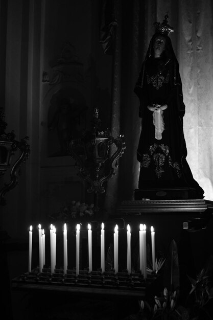 Foto estatua de la virgen maría frente a las velas encendidas