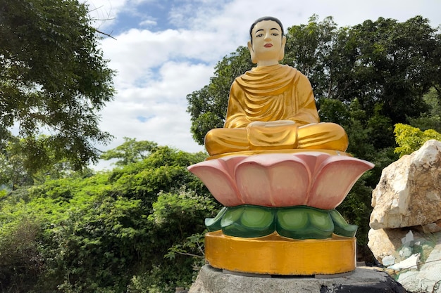 Estatuas de oro budistas asiáticas en un templo del jardín en Vietnam