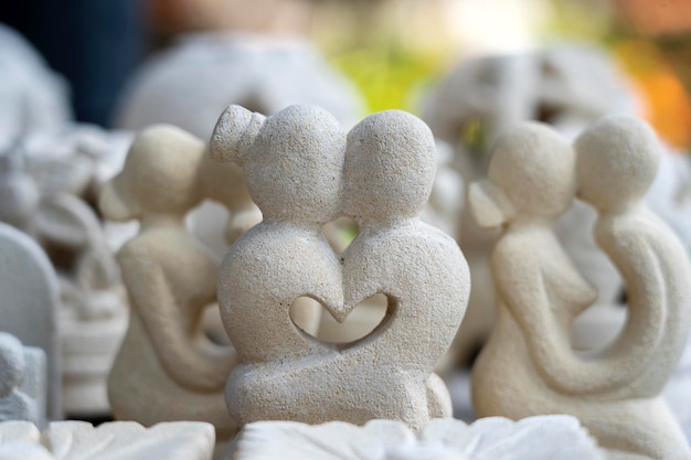 Estatueta de pedra de um casal apaixonado por um coração dentro de Souvenir em exposição à venda no mercado de rua em Ubud Bali Indonésia