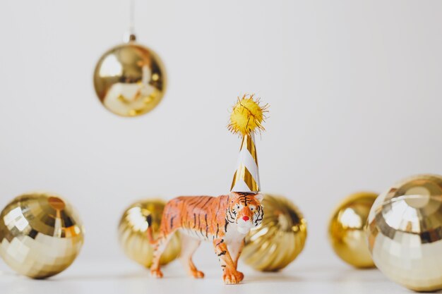 estatueta de tigre em tampa de festa com bolas douradas de natal, símbolo do ano novo chinês de 2022