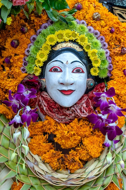 Estatueta tradicional de pedra balinesa da divindade decorada com flores no templo de rua Ilha Bali Indonésia Fechar