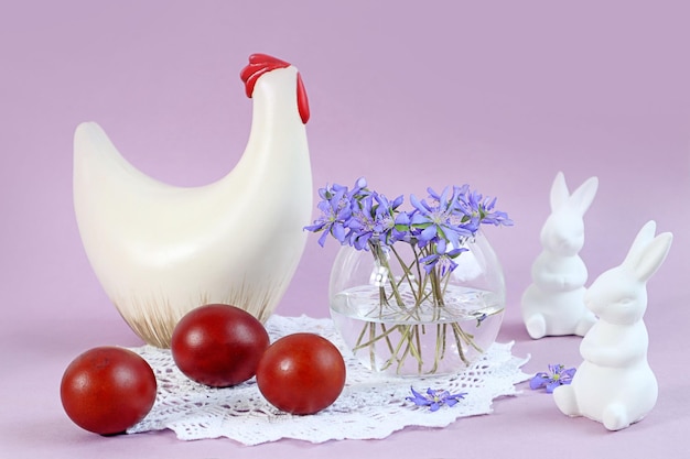 Estatuetas de cartão de Páscoa de frango e coelhos pintaram ovos um buquê de flores da primavera em um espaço de fundo pastel para texto