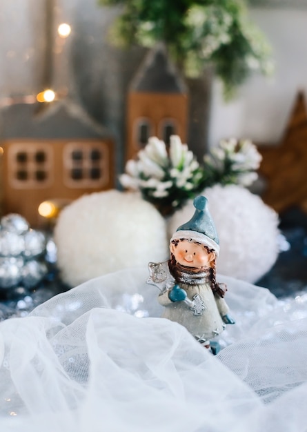 Estatuetas de crianças em porcelana em decoração de Natal. Estatuetas de inverno de um menino e uma menina com presentes no fundo de casas e cones. Cartão de Natal. Copie o espaço.